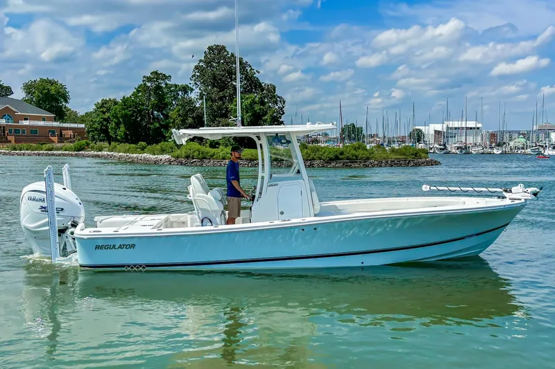 Slide: The Image of 2025 Regulator 26XO boat cruising on a sunny day near a marina. - 17