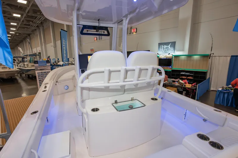 Slide: The Image of 2025 Regulator 26XO boat interior at a boat show, featuring seating and storage. - 2