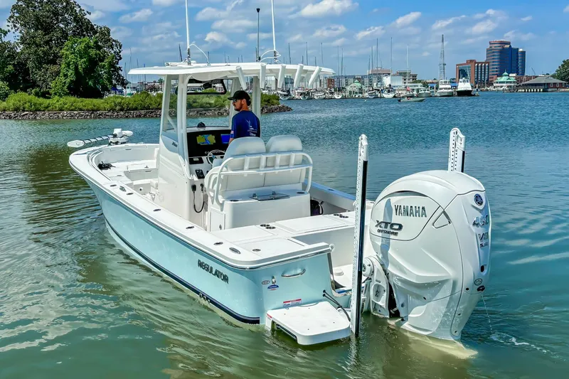 Slide: The Image of 2025 Regulator 26XO boat with Yamaha engine on calm water near marina. - 20
