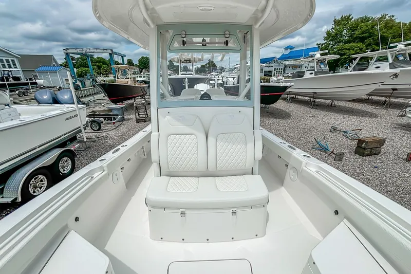 Slide: The Image of 2025 Regulator 26XO boat interior with white seating, docked among other boats. - 27