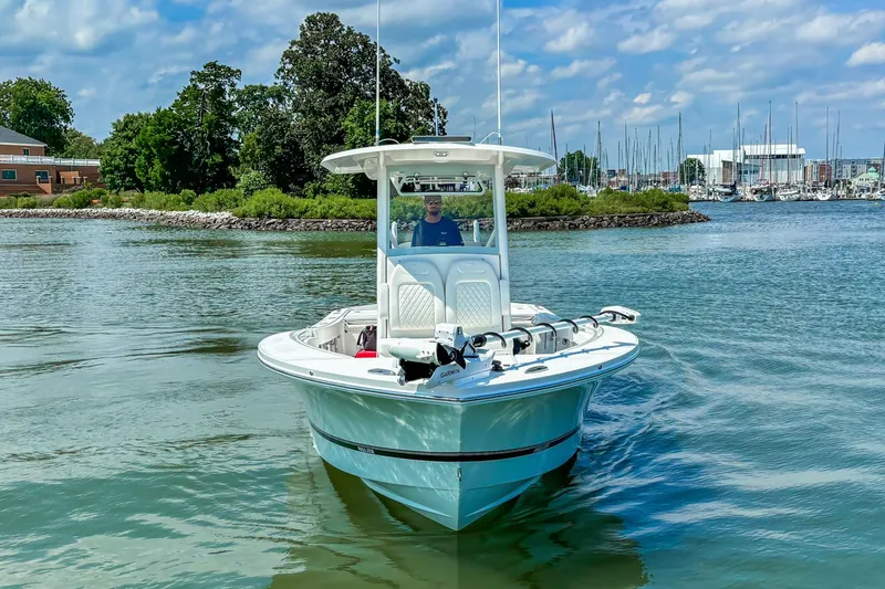 Slide: The Image of 2025 Regulator 26XO boat cruising on a scenic waterway with lush greenery. - 30