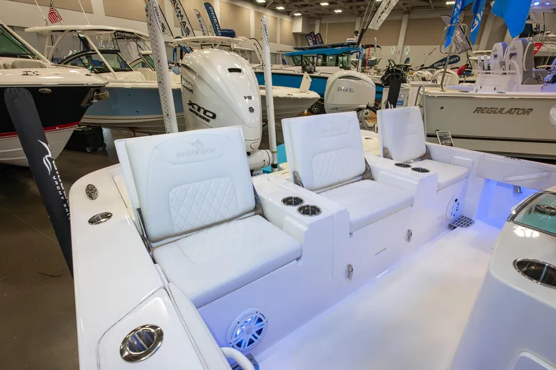 Slide: The Image of 2025 Regulator 26XO boat interior with white seating and Yamaha V8 engine at a boat show. - 4