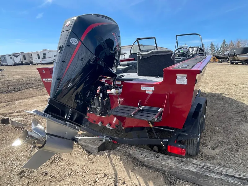 Slide: The Image of 2024 Tracker Targa V-19 Combo boat with powerful outboard motor in a parking lot. - 4