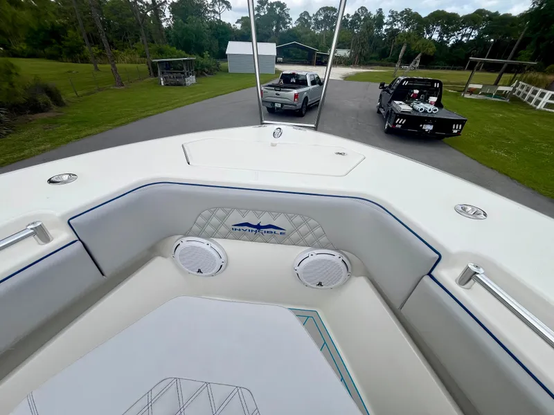 Slide: The Image of 2016 Invincible 33' Open Fisherman boat interior with view of the bow and parked trucks. - 9