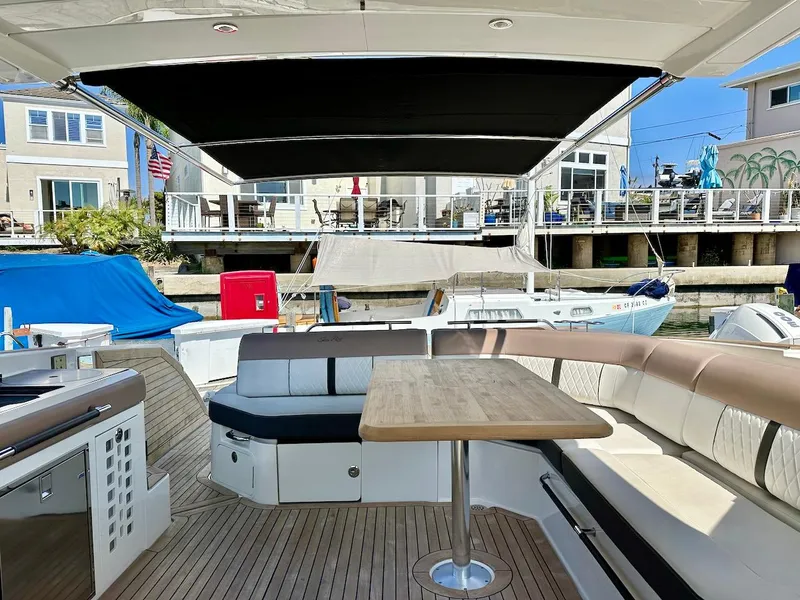 Slide: The Image of 2018 Sea Ray SLX 400 boat with spacious seating and dining area docked at marina. - 13