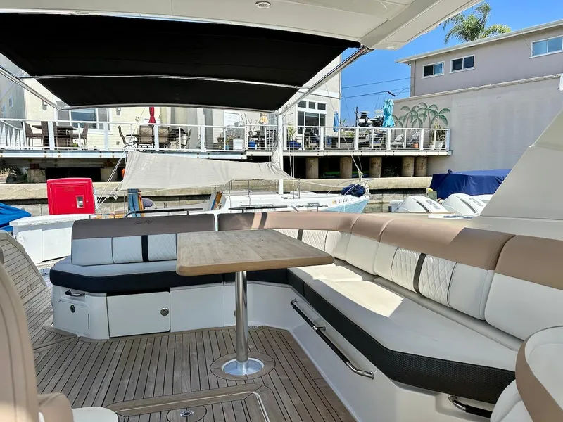 Slide: The Image of 2018 Sea Ray SLX 400 boat with spacious seating and table in the cockpit area. - 14