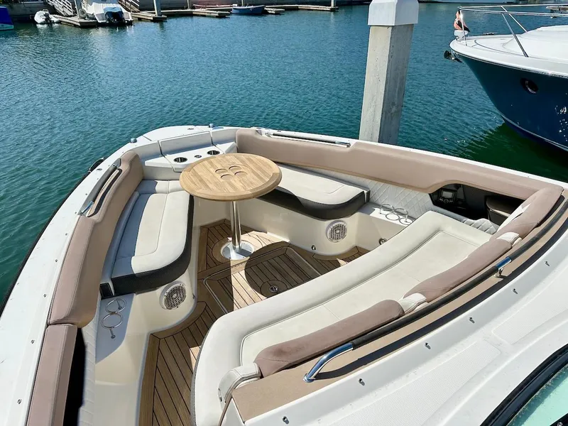 Slide: The Image of 2018 Sea Ray SLX 400 boat with spacious seating and table at the bow, docked in marina. - 19