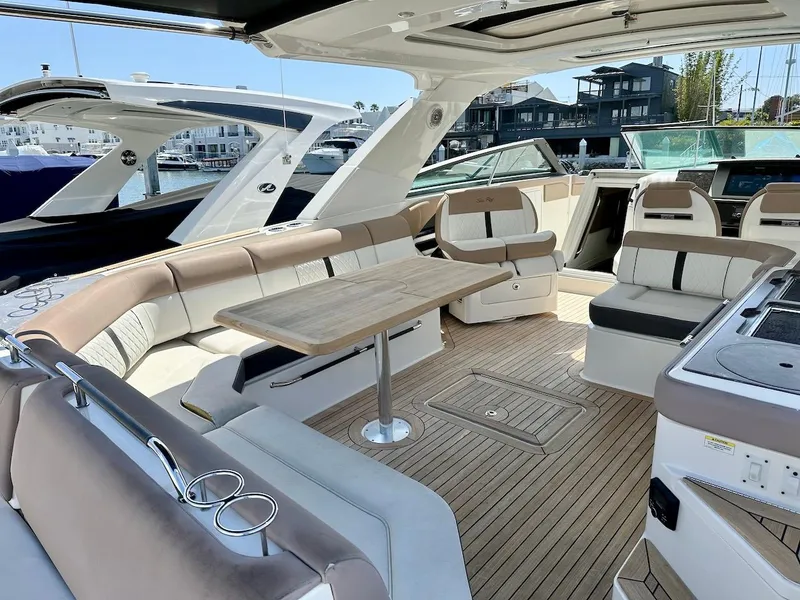 Slide: The Image of 2018 Sea Ray SLX 400 boat interior with spacious seating and wooden table. - 9