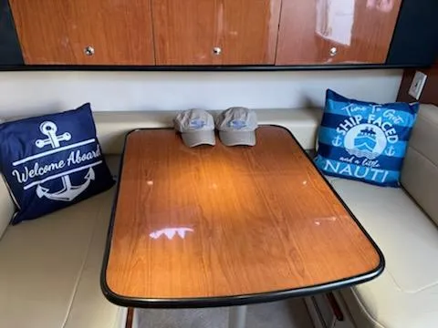 Slide: The Image of Chaparral 300 Signature 2000 interior with nautical-themed pillows and wooden table. - 11