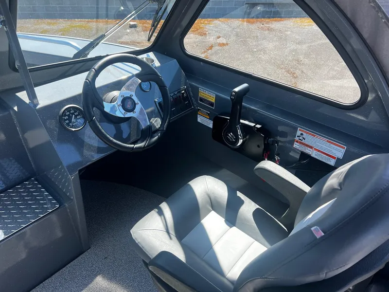 Slide: The Image of 2024 Fish Rite 200 Sportsman boat interior with steering wheel and captain's seat. - 10