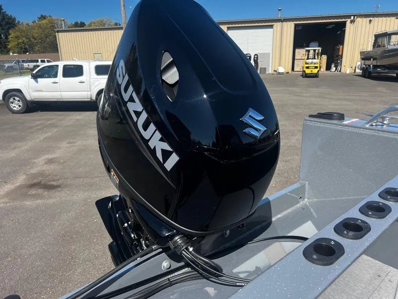 Slide: The Image of 2024 Fish Rite 200 Sportsman boat with Suzuki outboard motor in a parking lot. - 24