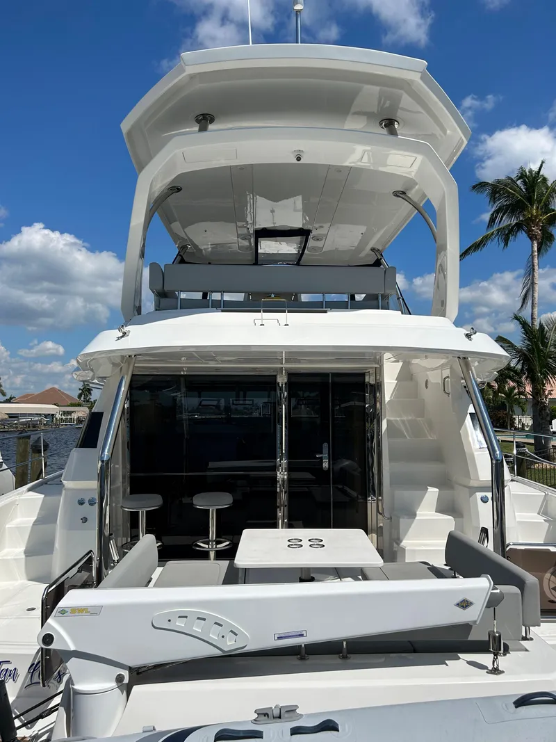 Slide: The Image of Aquila 44 Yacht 2020 model, rear view with seating, under a clear blue sky. - 2