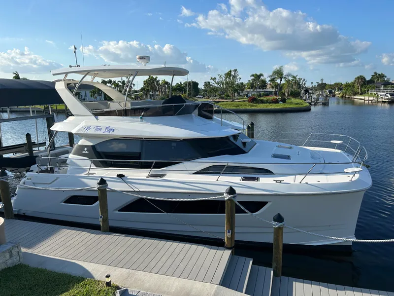 Slide: The Image of 2020 Aquila 44 Yacht docked by a scenic waterfront under a clear blue sky. - 24