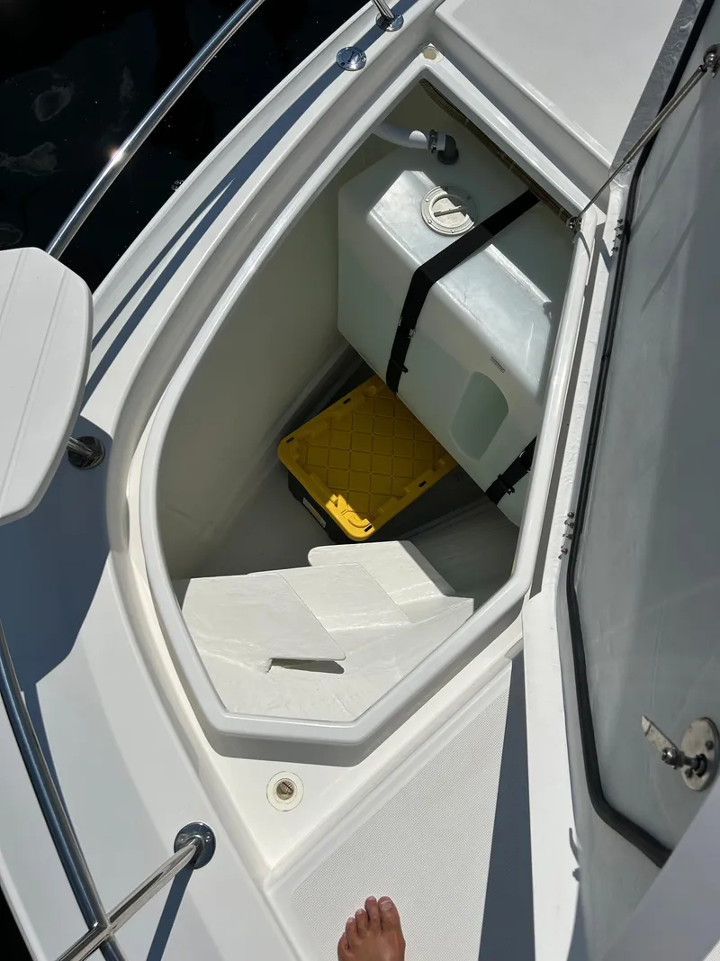 Slide: The Image of 2020 Aquila 44 Yacht storage compartment with yellow container and white interior. - 32