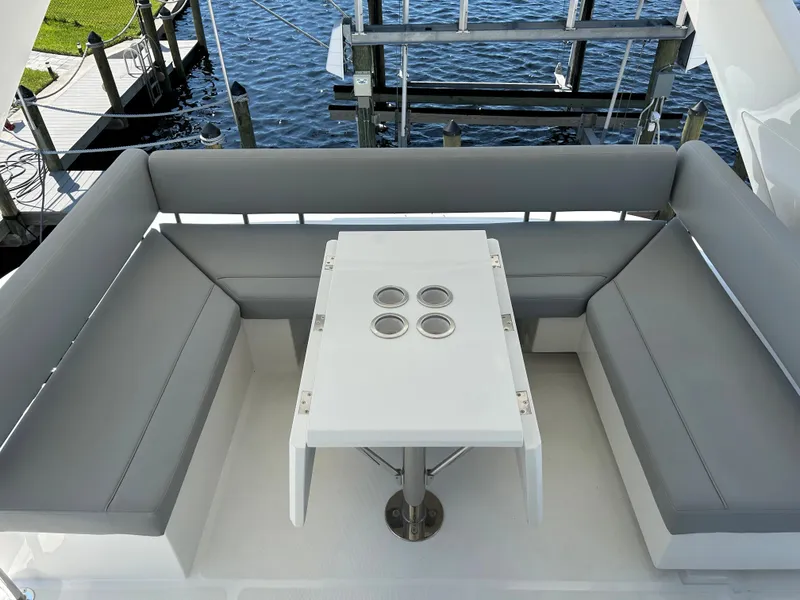 Slide: The Image of Aquila 44 Yacht 2020, outdoor seating area with gray cushions and a white table. - 35