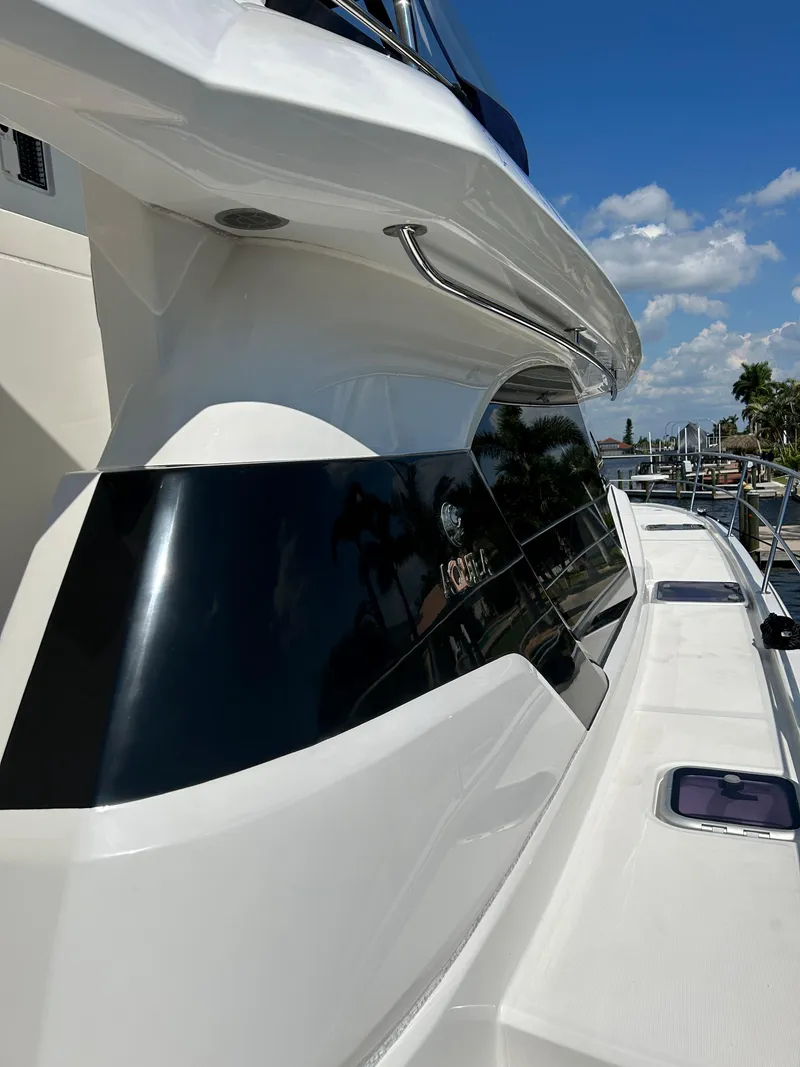 Slide: The Image of 2020 Aquila 44 Yacht, sleek design, docked under clear blue sky. - 37