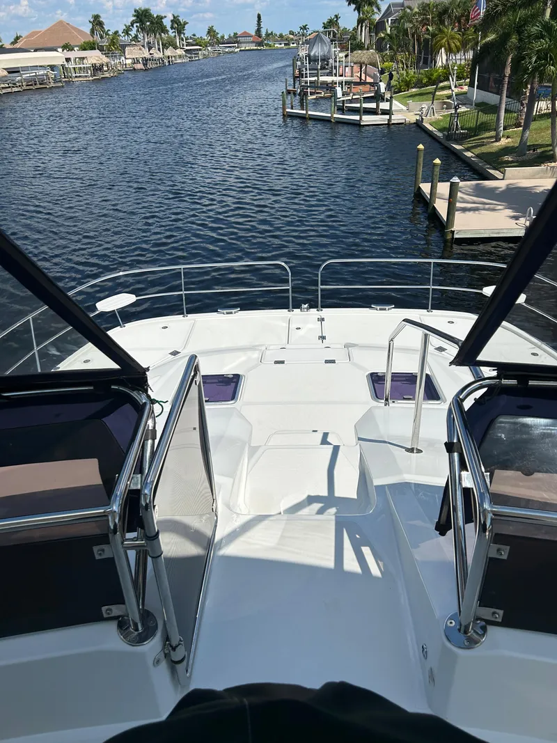 Slide: The Image of Aquila 44 Yacht 2020 on a serene waterfront, showcasing luxurious deck and scenic view. - 38