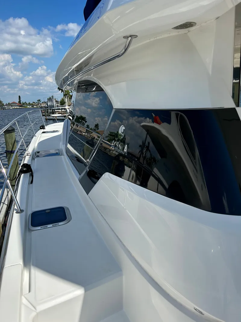 Slide: The Image of 2020 Aquila 44 Yacht with sleek design and reflective windows, docked under a blue sky. - 41