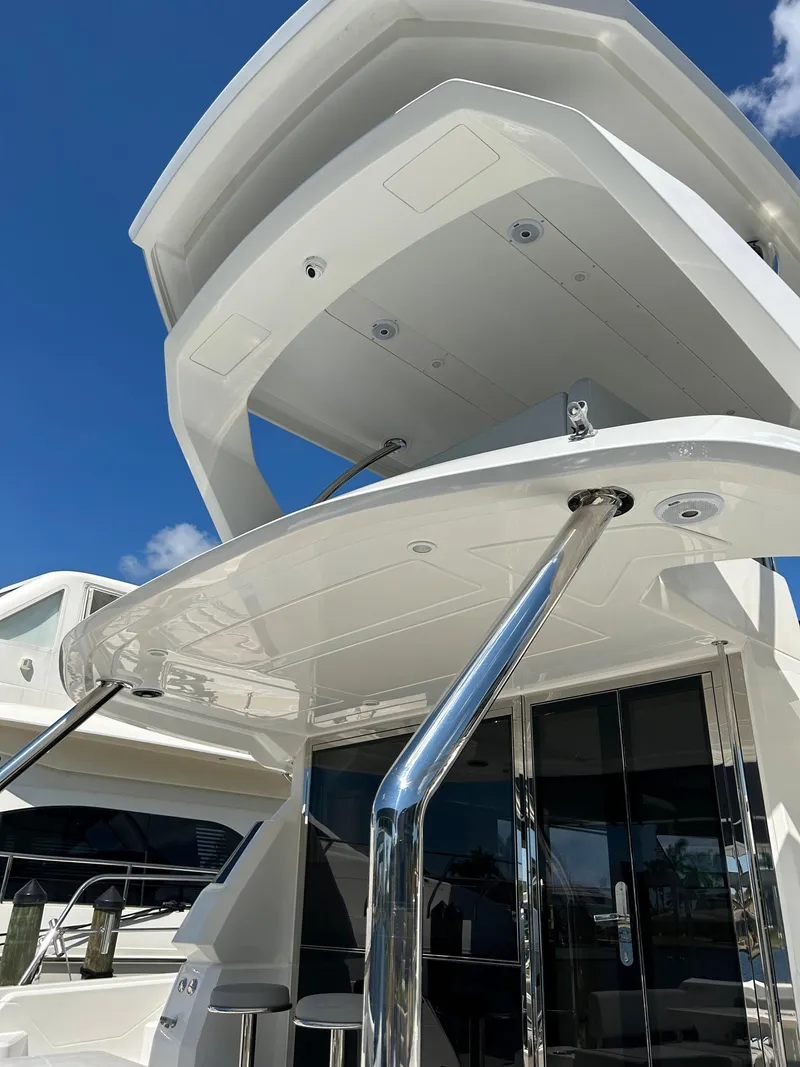 Slide: The Image of Aquila 44 Yacht 2020 model, showcasing sleek design and modern architecture under a clear blue sky. - 42