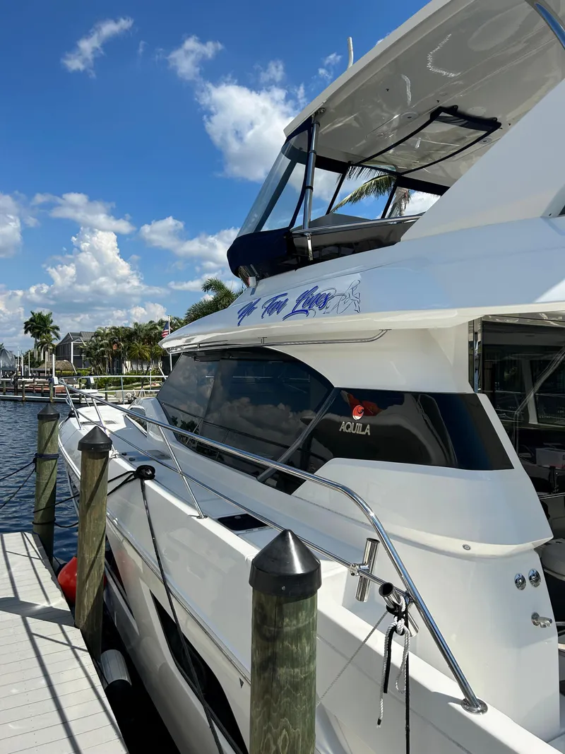 Slide: The Image of 2020 Aquila 44 Yacht docked under a clear blue sky. - 44