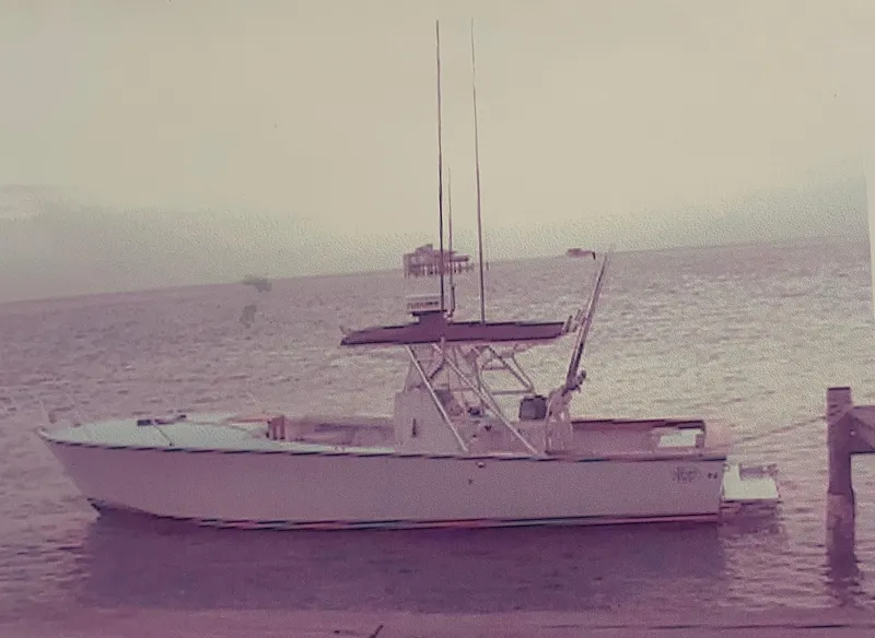 Slide: The Image of 2000 Stuart Angler 32 Center Console boat docked by the sea. - 1