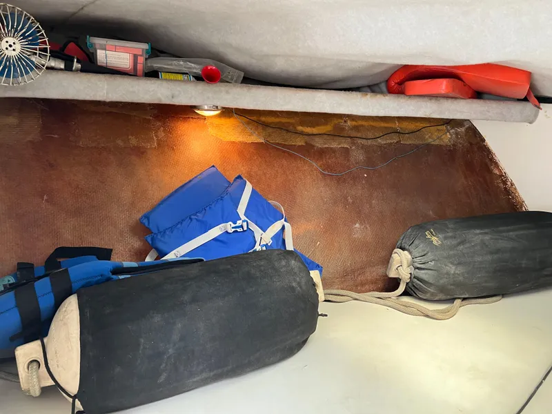 Slide: The Image of Interior of 2000 Stuart Angler boat with life jackets, fenders, and storage items. - 19