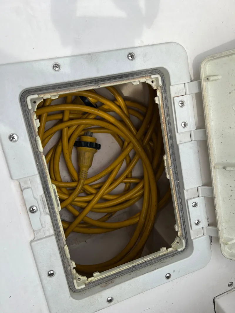 Slide: The Image of Yellow power cable stored in a compartment of a 2000 Stuart Angler 32 Center Console/Cutty. - 31