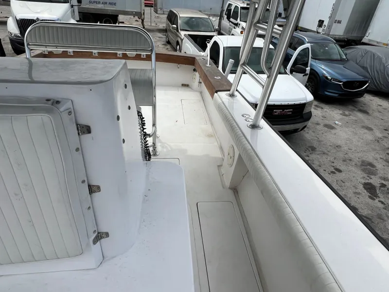 Slide: The Image of 2000 Stuart Angler 32 Center Console boat interior with parked vehicles in background. - 37