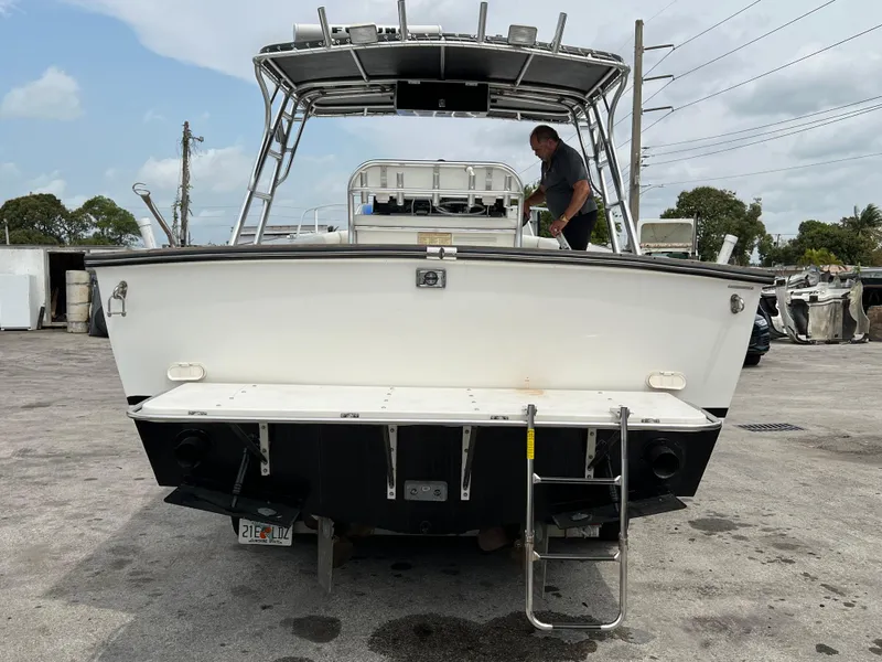 Slide: The Image of 2000 Stuart Angler 32 Center Console boat with ladder, docked on concrete surface. - 9