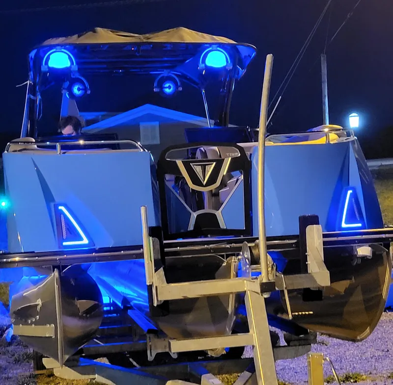 Slide: The Image of 2025 Trifecta 25 Sport RF9 DC 3.0+ pontoon boat with blue LED lights at night. - 4