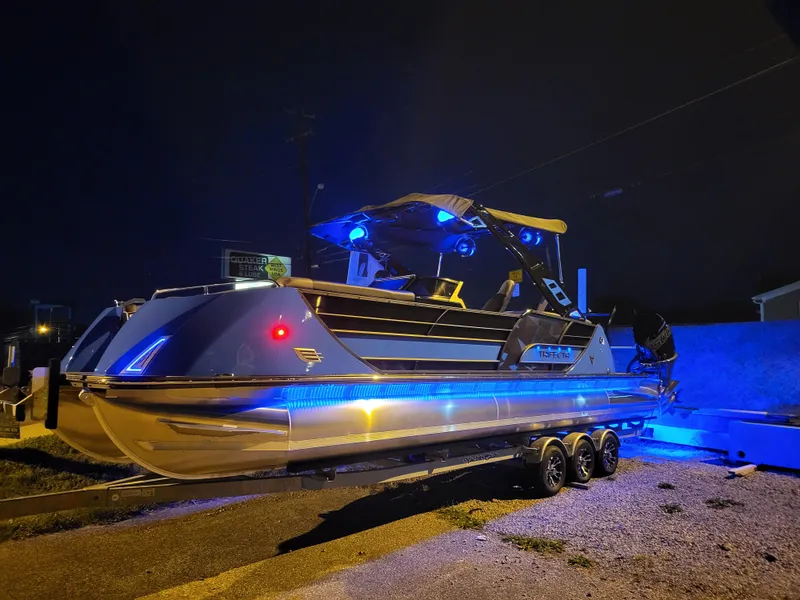 Slide: The Image of 2025 Trifecta 25 Sport RF9 DC 3.0+ pontoon boat illuminated at night. - 7