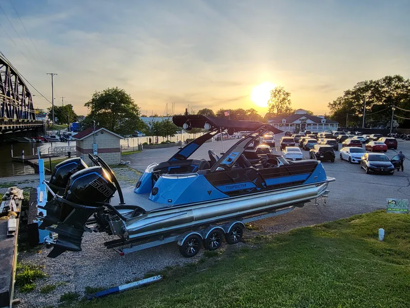 Slide: The Image of 2025 Trifecta 25 Sport RF9 DC 3.0+ boat on trailer at sunset near a parking lot. - 8