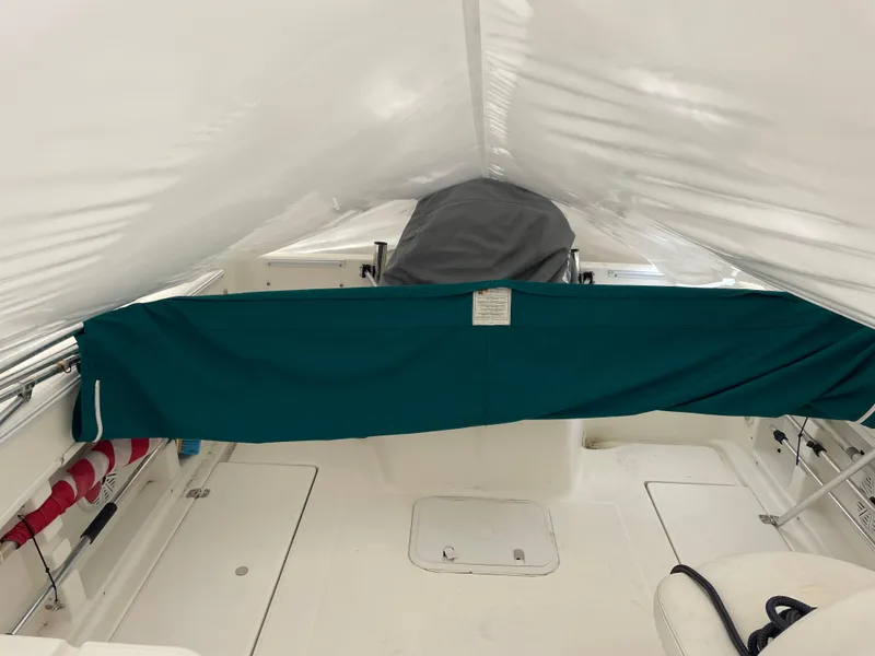 Slide: The Image of Interior view of a 2000 Aquasport Osprey Sport 21.5 boat under a white cover. - 12