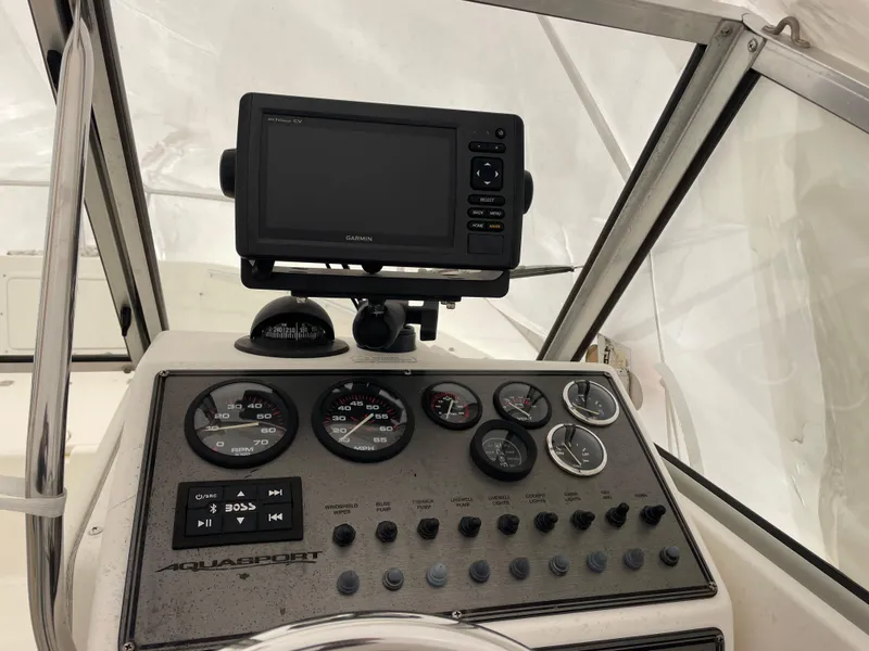 Slide: The Image of Dashboard of a 2000 Aquasport Osprey Sport 21.5 boat with gauges and navigation system. - 4