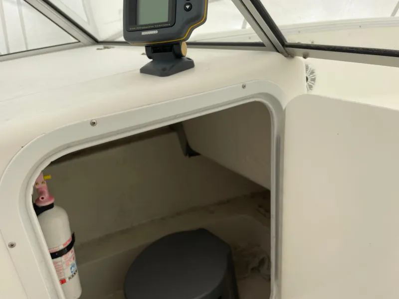 Slide: The Image of Cabin interior of 2000 Aquasport Osprey Sport 21.5 boat with fire extinguisher. - 7