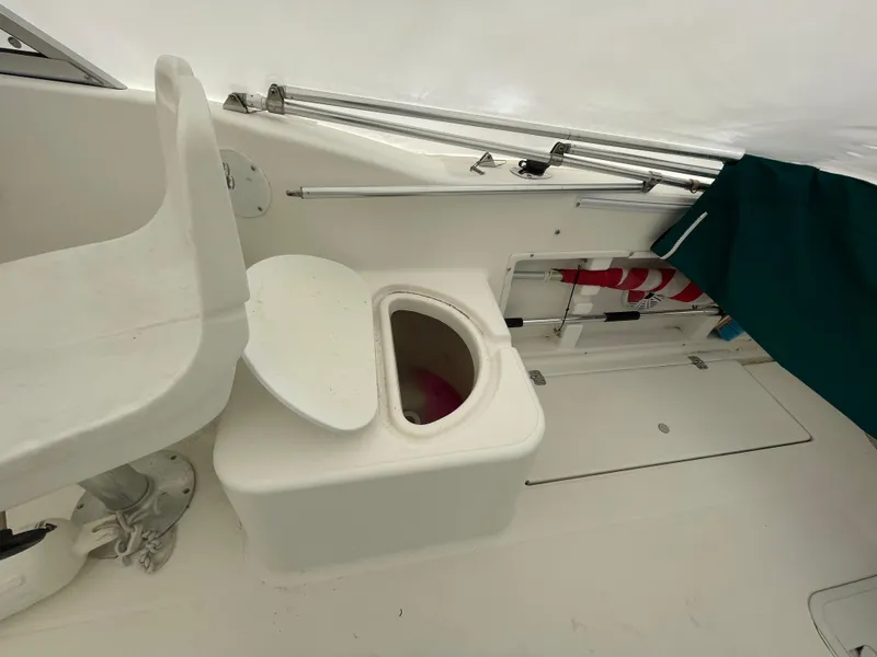 Slide: The Image of 2000 Aquasport Osprey Sport 21.5 boat interior with open toilet seat. - 9