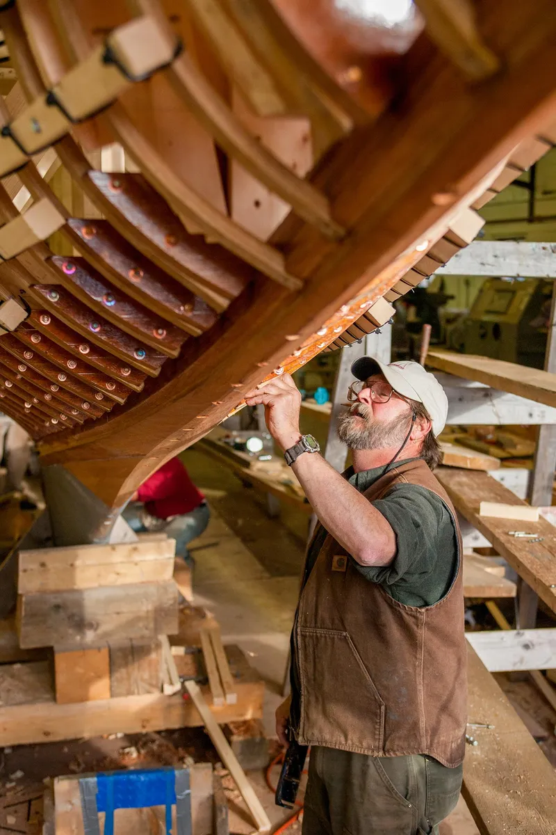 Slide: The Image of Man working on the hull of a 1931 Sparkman & Stephens 36 Sloop. - 12