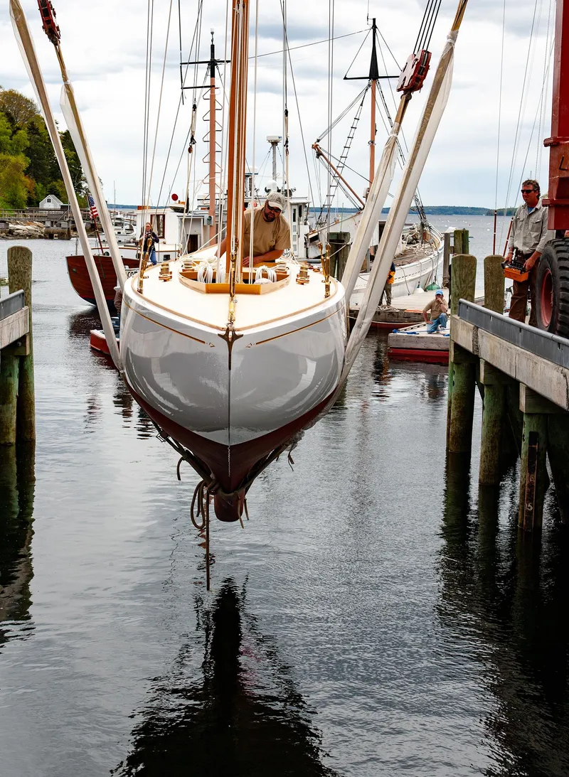 Slide: The Image of 1931 Sparkman & Stephens 36 Sloop being lowered into water at a marina. - 2
