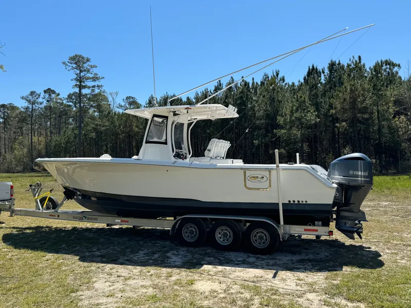 The Image of 2018 Sea Hunt Gamefish 30 boat on trailer, parked outdoors near forest. - 0