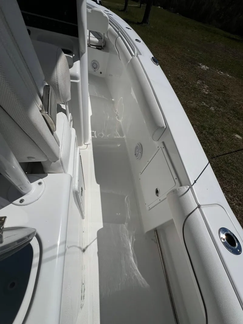 Slide: The Image of 2018 Sea Hunt Gamefish 30 boat interior, featuring white seating and storage compartments. - 14