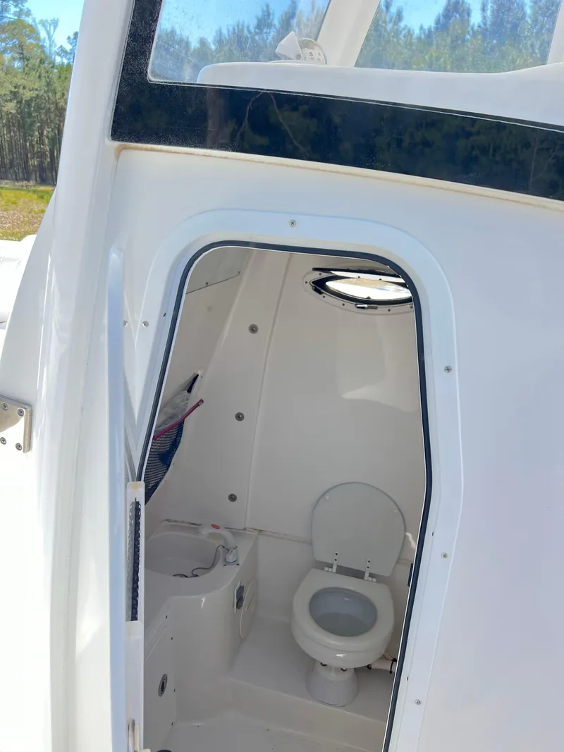 Slide: The Image of Interior view of 2018 Sea Hunt Gamefish 30 boat's compact bathroom with toilet. - 19