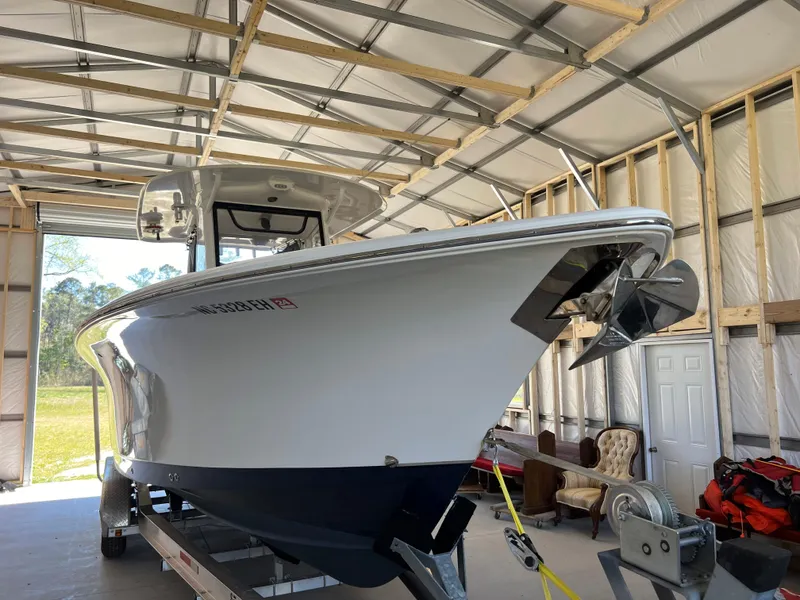 Slide: The Image of 2018 Sea Hunt Gamefish 30 boat in a garage, front view with trailer. - 2