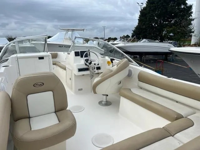 Slide: The Image of 2020 Key West 239 DFS boat interior with beige and white seating, steering wheel, and dashboard. - 20