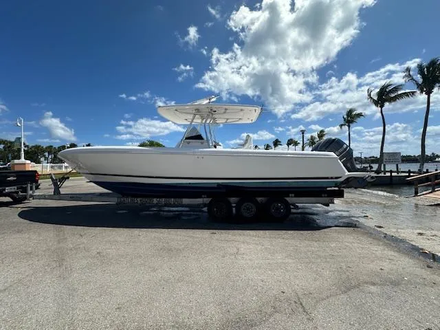 Slide: The Image of 2013 Intrepid 327 Center Console boat on a trailer at a marina. - 2