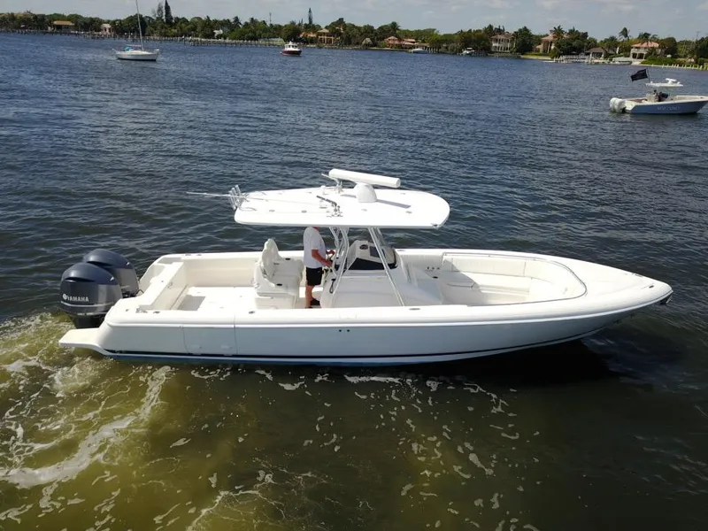 Slide: The Image of 2013 Intrepid 327 Center Console boat cruising on a calm lake. - 3
