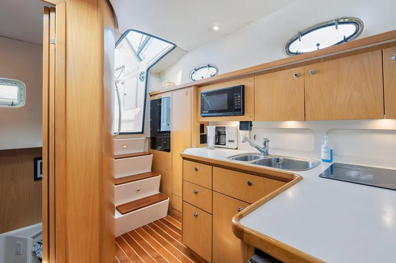 Slide: The Image of 1999 Tiara Yachts 4000 Express interior kitchen with wooden cabinetry and modern appliances. - 11