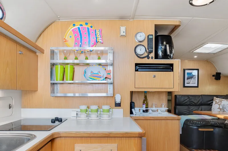 Slide: The Image of 1999 Tiara Yachts 4000 Express kitchen with wooden cabinetry and colorful decor. - 12