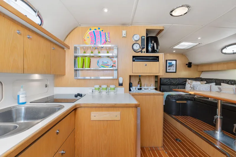 Slide: The Image of 1999 Tiara Yachts 4000 Express interior with kitchen and lounge area. - 13