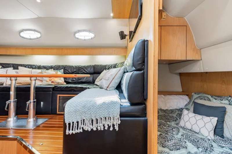 Slide: The Image of Interior of 1999 Tiara Yachts 4000 Express with cozy seating and sleeping area. - 14