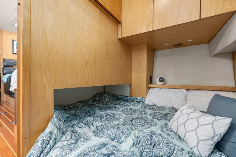 Slide: The Image of Cozy bedroom in 1999 Tiara Yachts 4000 Express with patterned bedding and wooden cabinetry. - 15